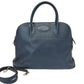 Blue leather handbag with a strap on a white background