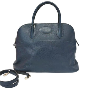Blue leather handbag with a strap on a white background