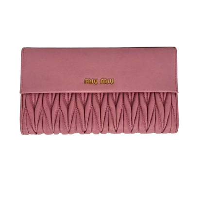 Pink quilted wallet with brand logo on a light gray background
