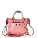 Pink handbag with a strap on a white background
