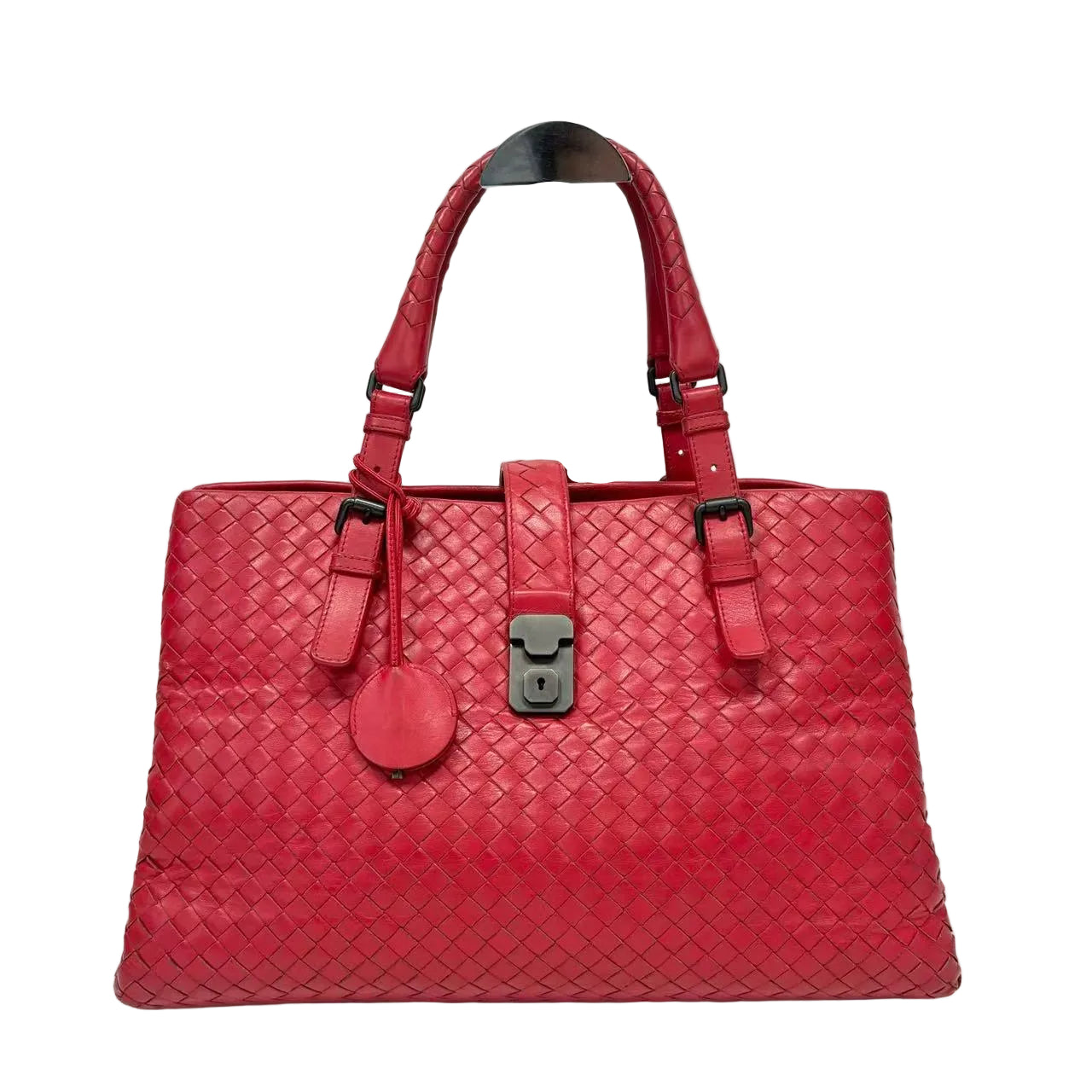 Red woven handbag with a silver lock on a white background