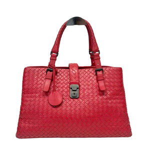 Red woven handbag with a silver lock on a white background