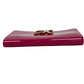 Pink clutch bag with a gold logo on a white background