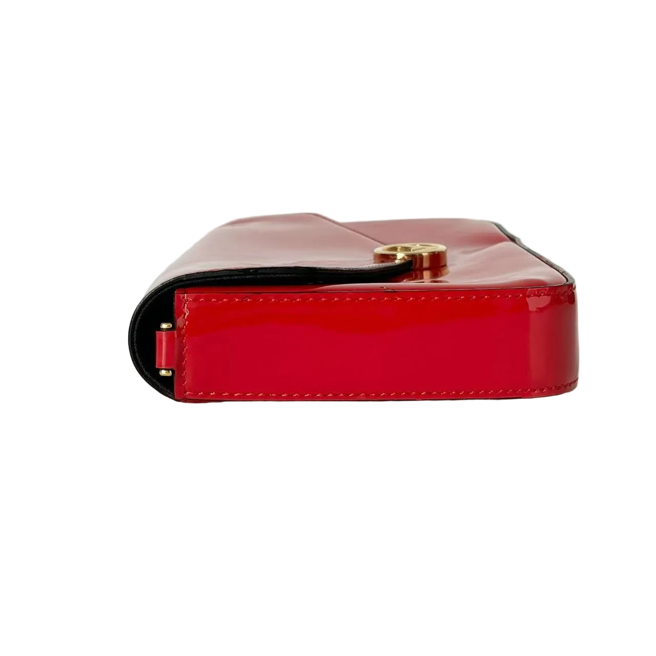 Red patent leather wallet with gold clasp on a light gray background